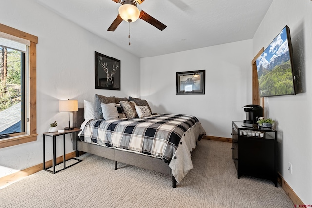 carpeted bedroom with a ceiling fan and baseboards