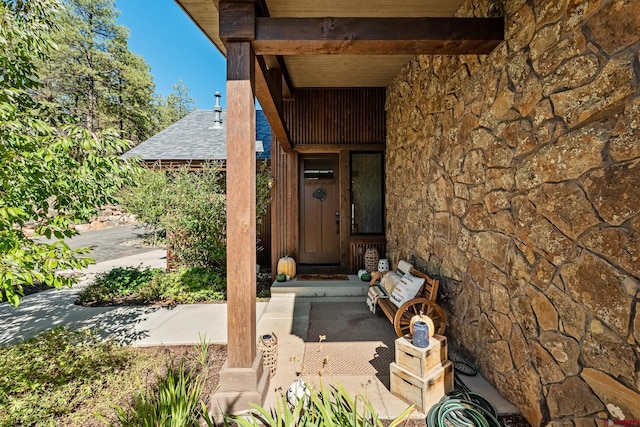 doorway to property with a shingled roof