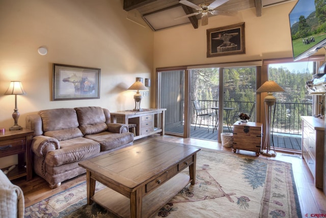 living area featuring ceiling fan, high vaulted ceiling, beamed ceiling, and wood finished floors