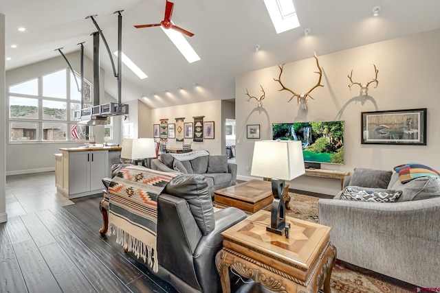 living room featuring a skylight, recessed lighting, dark wood-type flooring, ceiling fan, and high vaulted ceiling