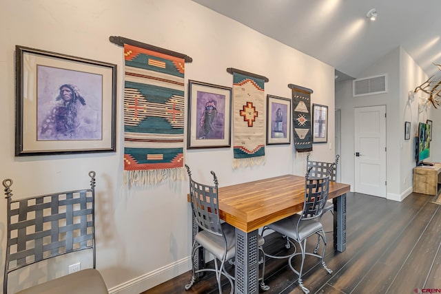 dining area featuring baseboards, visible vents, vaulted ceiling, and wood finished floors