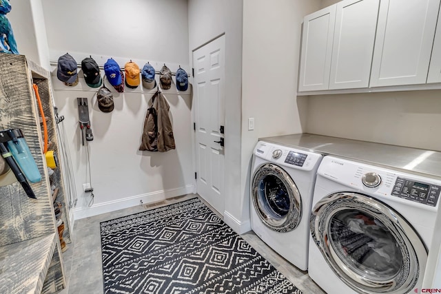 washroom featuring cabinet space, baseboards, and separate washer and dryer