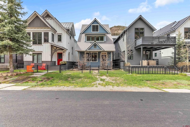 view of front of property featuring a fenced front yard, a standing seam roof, metal roof, and board and batten siding