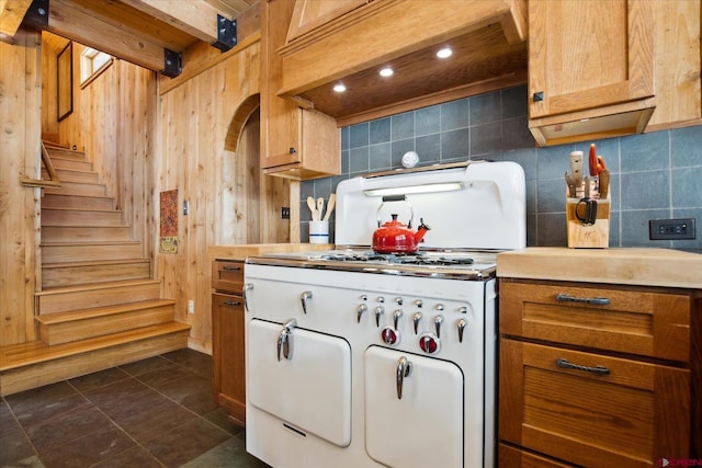 kitchen with light countertops, backsplash, custom exhaust hood, and dark tile patterned floors