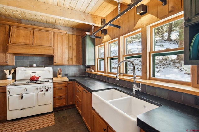 kitchen with wood ceiling, backsplash, a sink, white gas stove, and beam ceiling