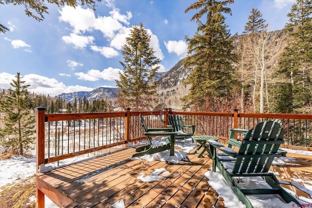 wooden terrace featuring a forest view and a mountain view