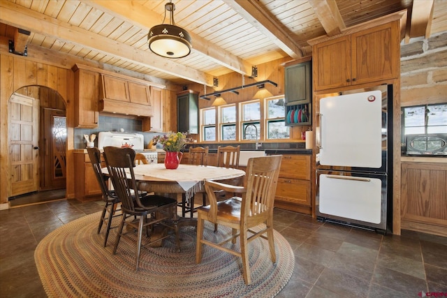 dining space with wood ceiling, beamed ceiling, and wooden walls