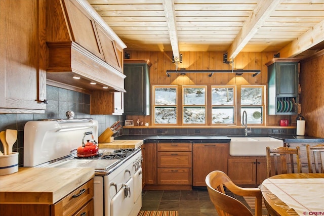 kitchen with beam ceiling, gas range gas stove, tasteful backsplash, wood ceiling, and a sink