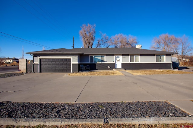 ranch-style home featuring concrete driveway and an attached garage