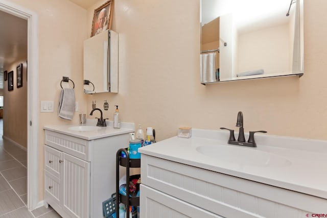 bathroom featuring tile patterned flooring, two vanities, and a sink