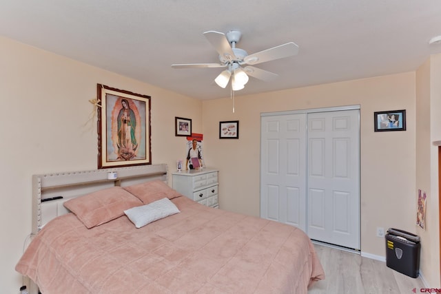 bedroom with a ceiling fan, a closet, and wood finished floors