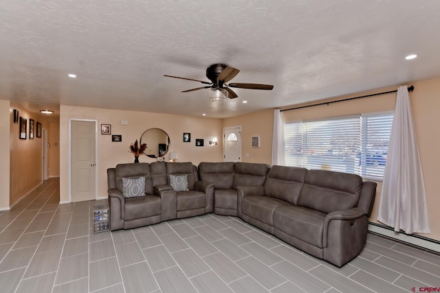 living room with ceiling fan, a baseboard heating unit, a textured ceiling, and recessed lighting