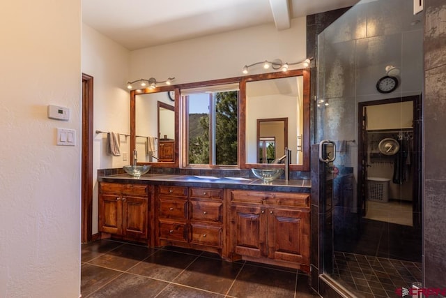 full bathroom featuring a sink, double vanity, a shower stall, and tile patterned floors