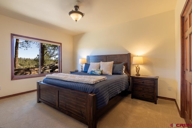 bedroom with baseboards and light colored carpet