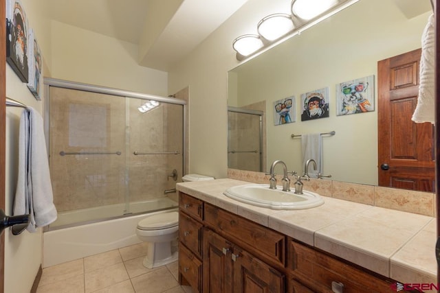 full bathroom with tile patterned flooring, vanity, toilet, and bath / shower combo with glass door