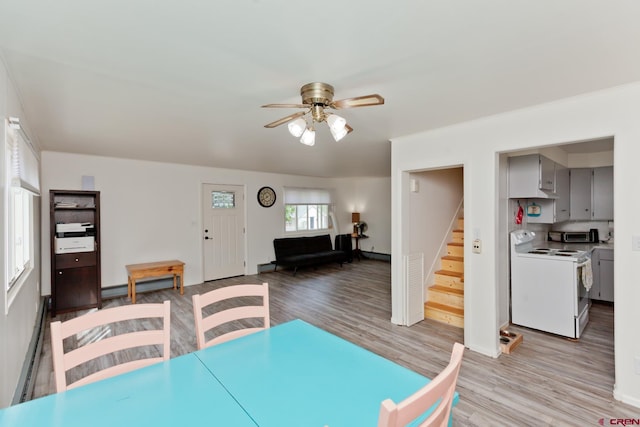 dining room featuring a ceiling fan, a baseboard radiator, stairs, baseboard heating, and light wood-style floors