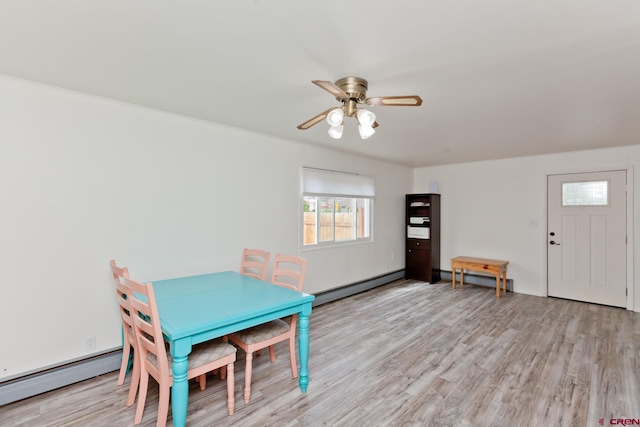 unfurnished dining area with a ceiling fan, a baseboard radiator, light wood-style flooring, and baseboard heating