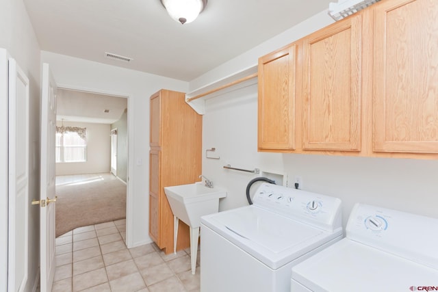 clothes washing area with light tile patterned floors, cabinet space, visible vents, light carpet, and independent washer and dryer