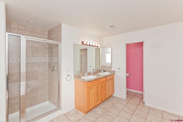 full bath with double vanity, a stall shower, visible vents, and a sink