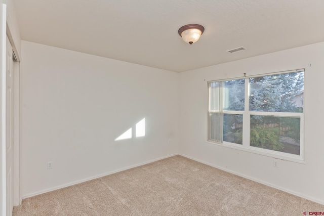 spare room with baseboards, visible vents, and carpet flooring