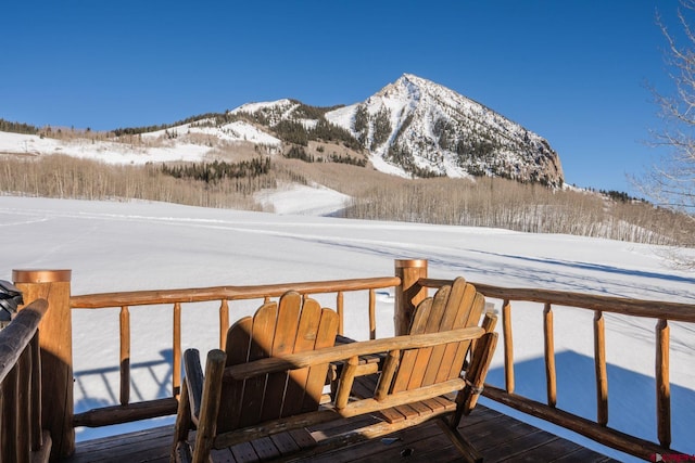 snow covered deck with a mountain view