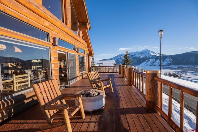 snow covered deck with a mountain view