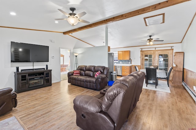 living area featuring vaulted ceiling with beams, ceiling fan, wainscoting, light wood finished floors, and crown molding