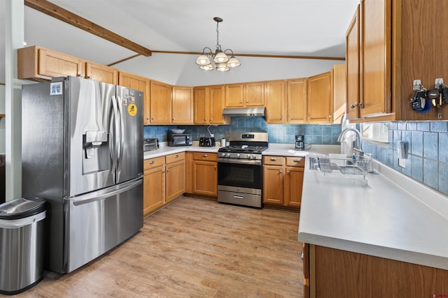 kitchen with tasteful backsplash, lofted ceiling with beams, appliances with stainless steel finishes, under cabinet range hood, and a sink