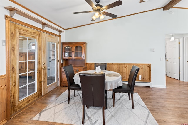 dining area with lofted ceiling with beams, wood finished floors, a ceiling fan, ornamental molding, and baseboard heating