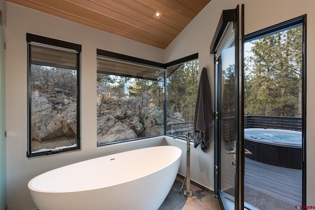 bathroom featuring vaulted ceiling, tile patterned flooring, wooden ceiling, and a freestanding bath