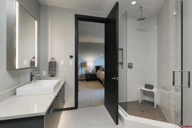 ensuite bathroom featuring tile patterned floors, connected bathroom, vanity, and walk in shower