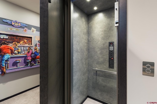 interior details featuring carpet, elevator, and baseboards