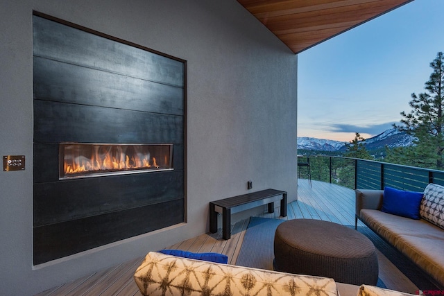 balcony featuring an outdoor living space with a fireplace and a mountain view