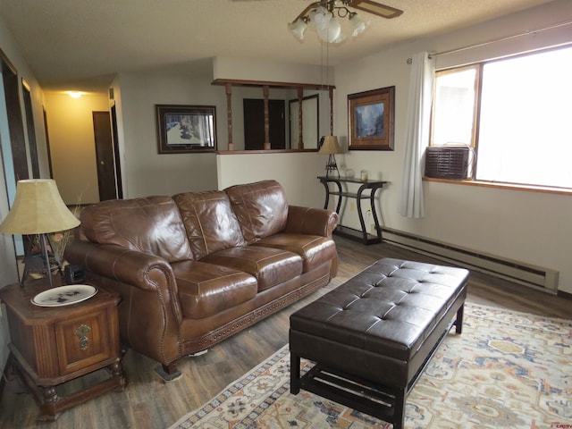 living room with a ceiling fan, baseboard heating, and wood finished floors