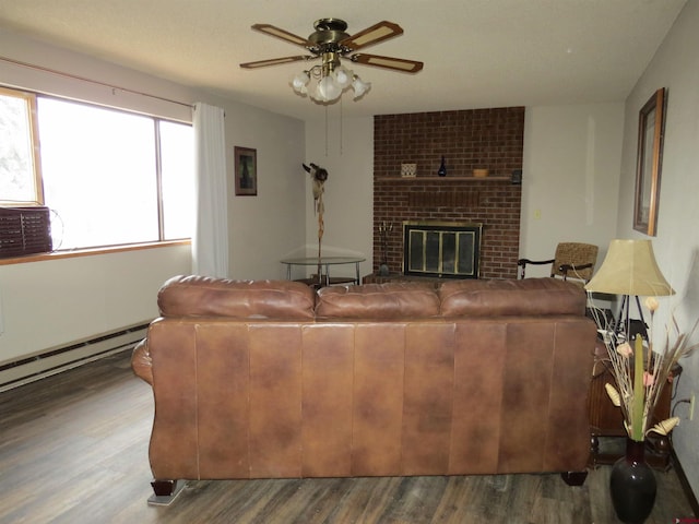 living room featuring a baseboard heating unit, a fireplace, wood finished floors, and a ceiling fan