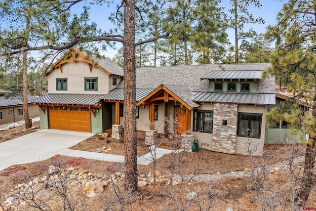 view of front of house with driveway, a standing seam roof, stone siding, and metal roof