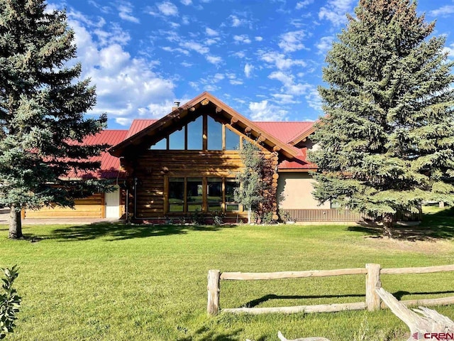 view of front of house with a front yard, metal roof, and fence