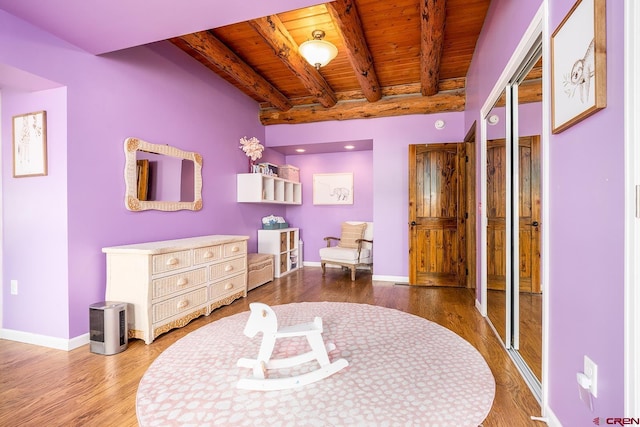 bedroom featuring beamed ceiling, wooden ceiling, wood finished floors, and baseboards