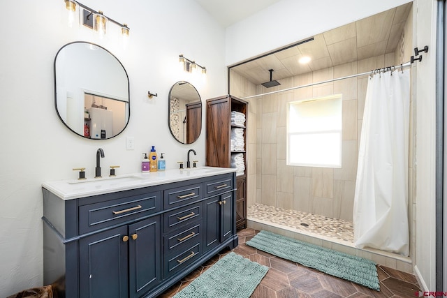 bathroom with double vanity, a tile shower, and a sink