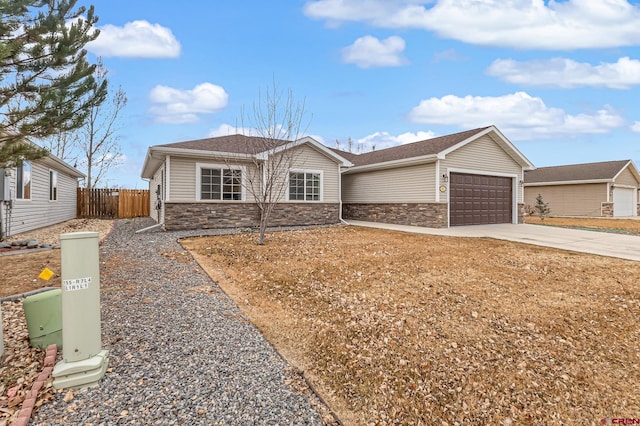 single story home featuring a garage, stone siding, fence, and driveway