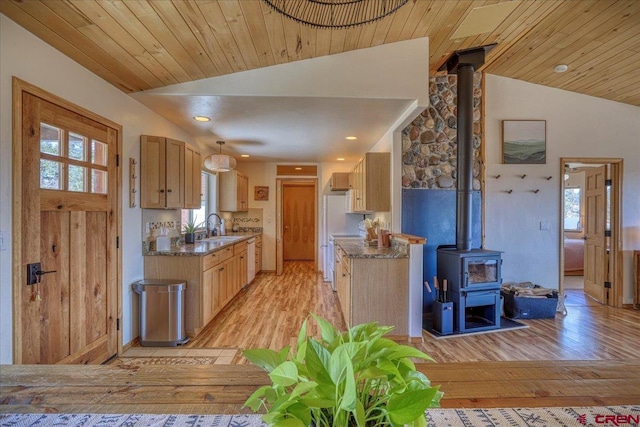 kitchen featuring a wood stove, light wood-style flooring, wood ceiling, and vaulted ceiling