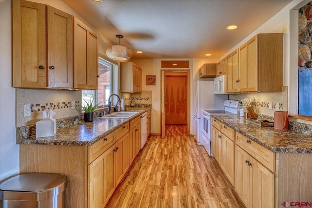 kitchen featuring tasteful backsplash, recessed lighting, light wood-style flooring, a sink, and white appliances