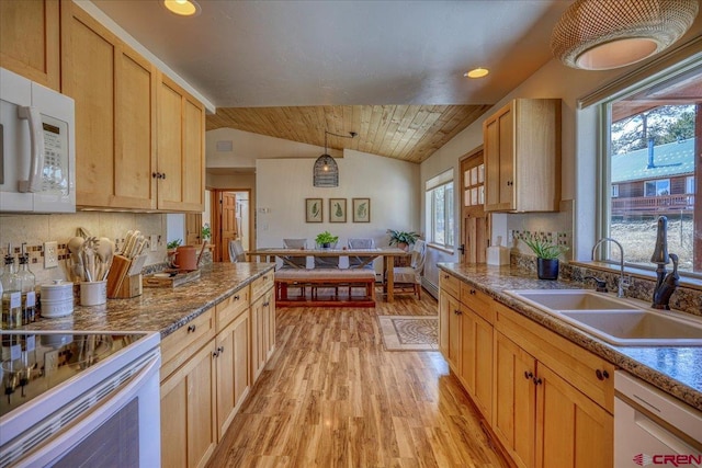 kitchen with light wood-type flooring, white appliances, vaulted ceiling, and a sink