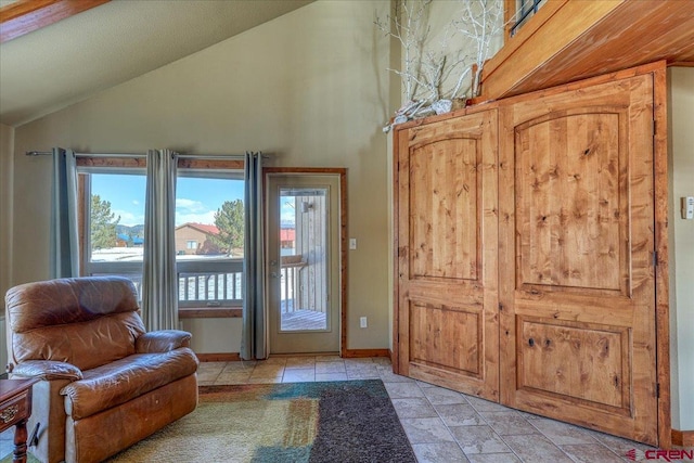 doorway featuring baseboards and vaulted ceiling