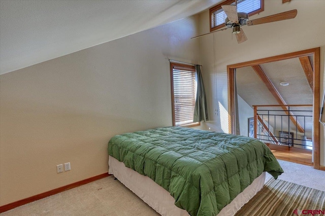 carpeted bedroom featuring lofted ceiling, ceiling fan, and baseboards