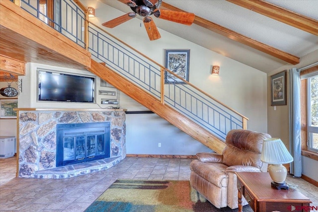 living area with lofted ceiling with beams, stairs, baseboards, and a fireplace