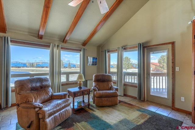 living area with baseboards, plenty of natural light, beamed ceiling, and stone tile floors