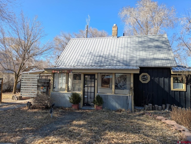 view of front of property with metal roof and a chimney