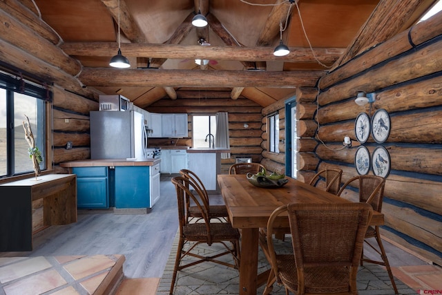 unfurnished dining area with vaulted ceiling with beams, light wood-type flooring, and a sink