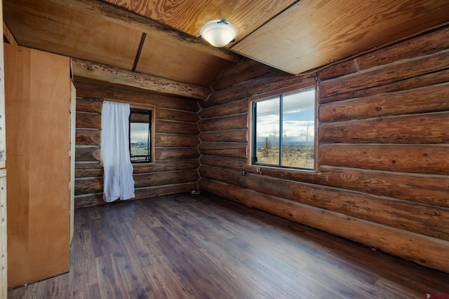 spare room featuring dark wood-type flooring, rustic walls, wooden ceiling, and vaulted ceiling